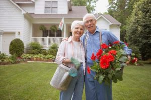 Couple holding watering can and flowers